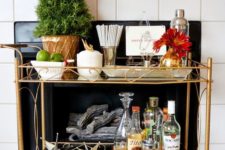 07 a holiday bar cart with an evergreen tree in a pot and some gilded star ornaments for Christmas