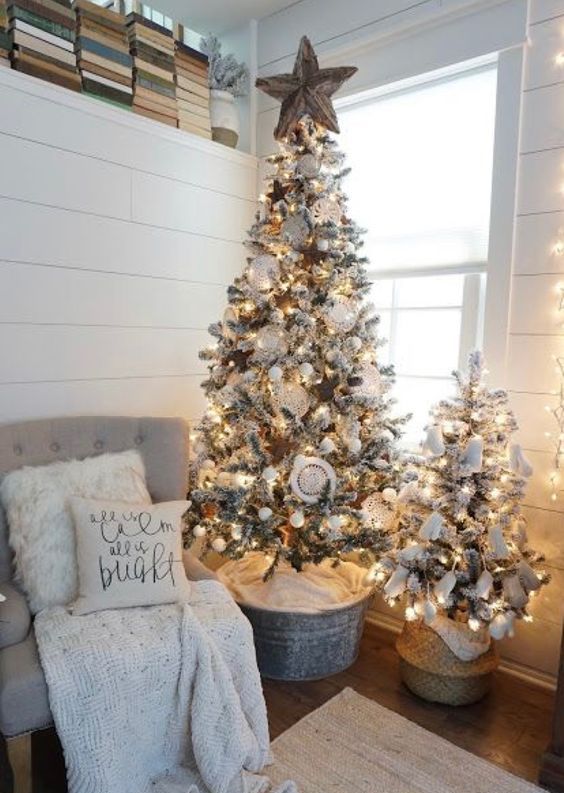 a cute duo of flocked Christmas trees with lights, white ornaments and pompoms for a neutral space