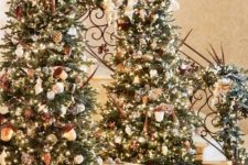 12 a duo of gorgeous and luxuriously decorated Christmas trees with lights, acorns and other ornaments
