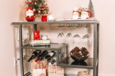 13 a cute Christmas bar cart with Santa mugs, Christmas trees, pinecones in a bowl and gifts