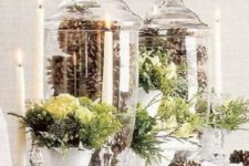 13 tall glass jars filled with pinecones and with greenery arrangements are a great idea for a centerpiece