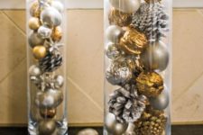 16 tall glass vases filled with snowy pinecones and metallic ornaments and nuts for festive decor