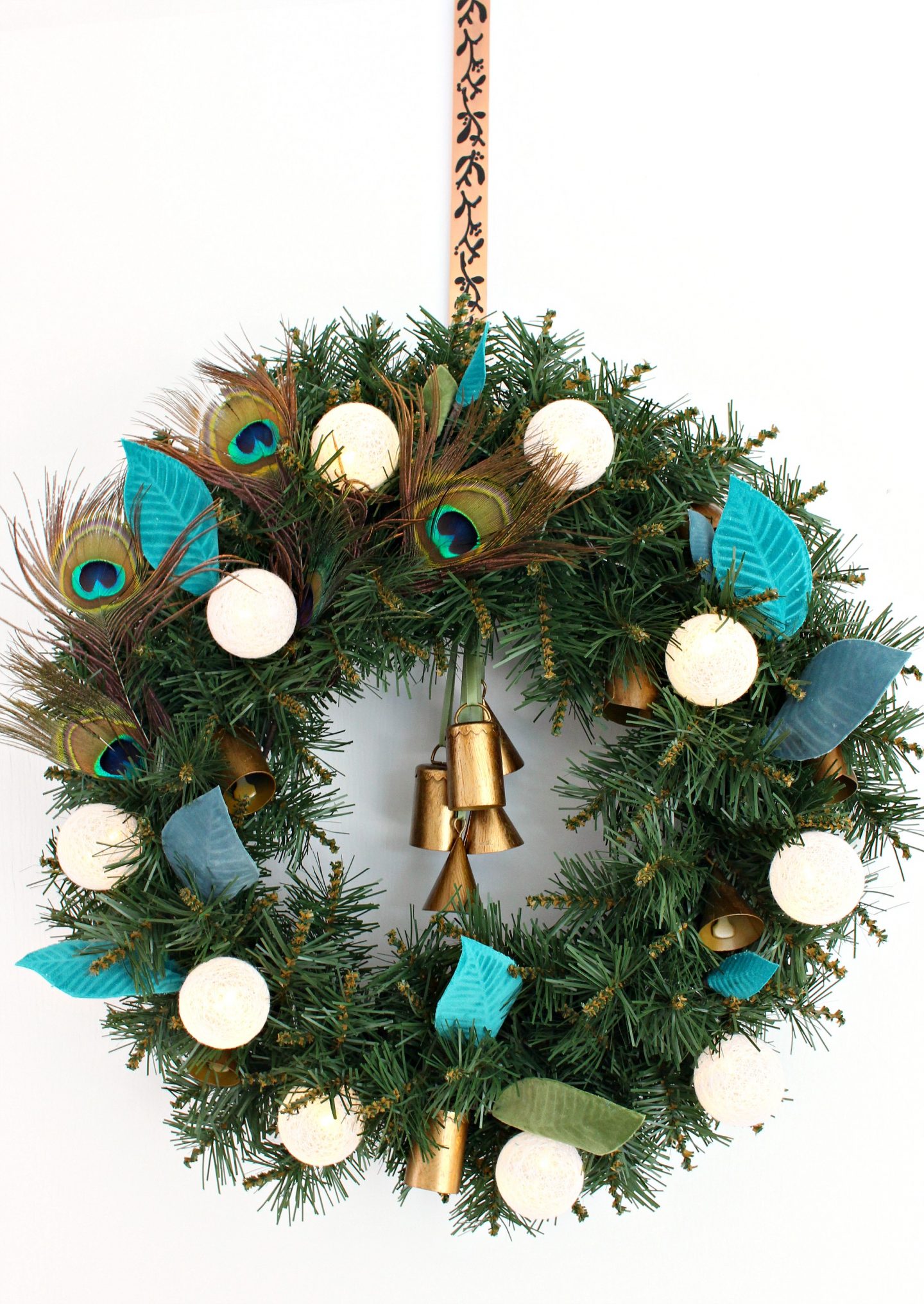 DIY boho lux Christmas wreath with peacock feathers and bells (via www.danslelakehouse.com)