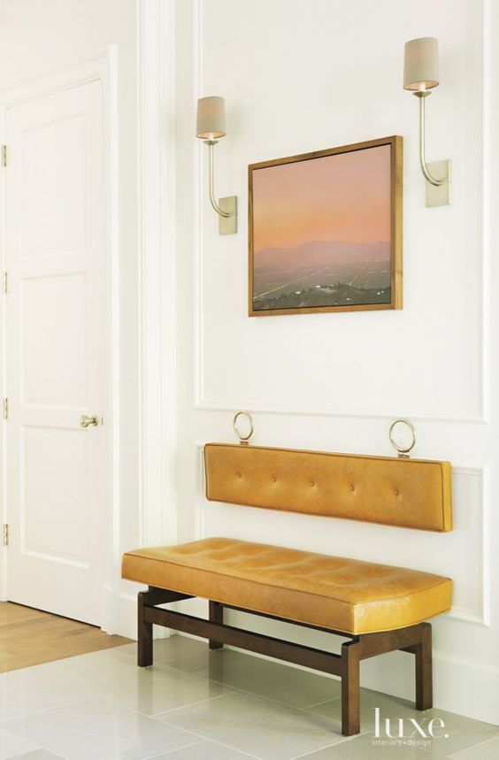 a cool mustard bench with wooden framing and a suspended back on rings