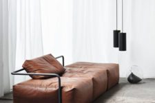 06 a minimalist brown leather sofa with black framing and black pendant lamps that echo