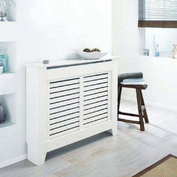 a minimalist white plank unit with an additional storage top and screens that are proper to hide radiators
