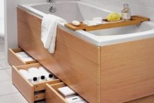 10 a bathtub clad with wood with several drawers under the bathtub for smart and comfy storage
