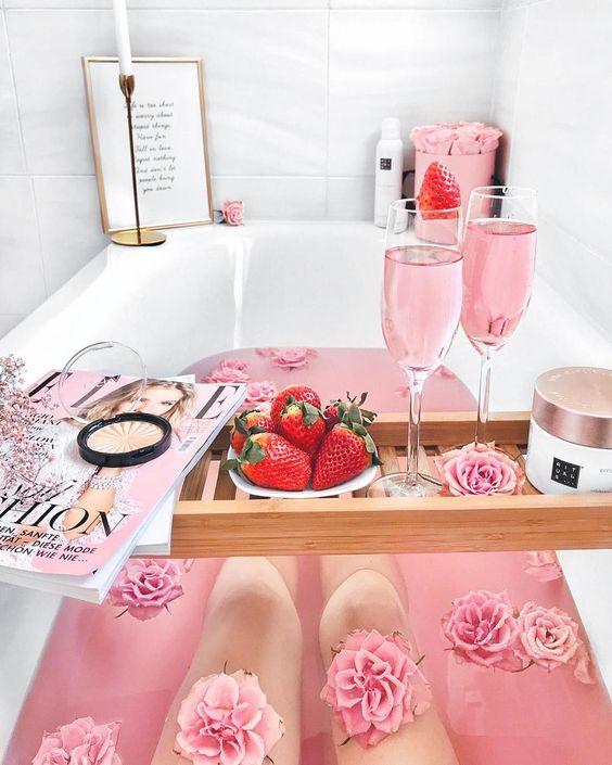 a pink bath for Valentine's Day with pink roses, pink wine, fresh strawbrries and a luxury scrub