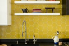 11 bold yellow hex tiles with white grout accent the black cabinets and add color to the space