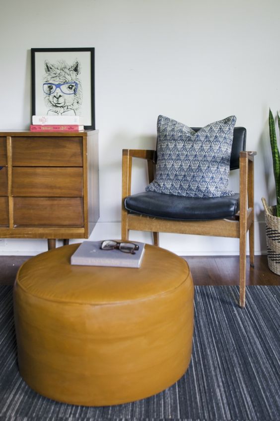 a round mustard leather ottoman is a bold accessory for a mid-century modern home