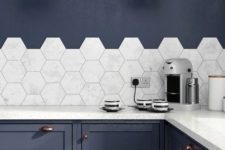 16 marble medium scale hex tiles accent the navy kitchen and create a contrating look