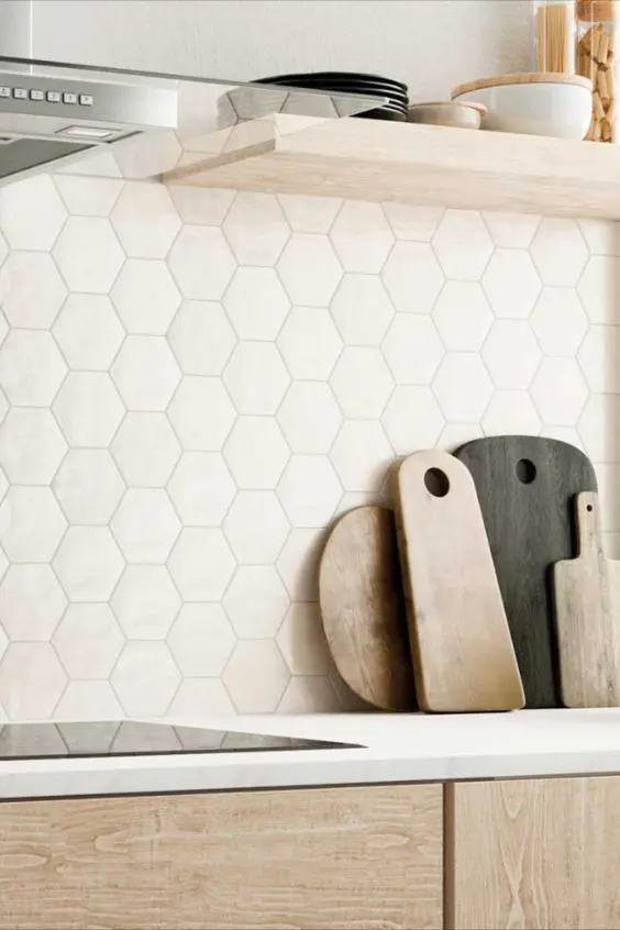 A beautiful light stained kitchen with a neutral hexagon tile backsplash and open shelves looks fresh and elegant