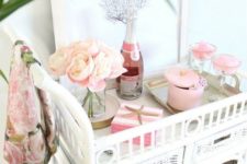 a blush pink bar cart with some blush blooms, boxes and straws is a cute idea