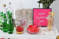 a bright Galentine party bar cart with a marble heart and tassel garland, with pink roses and a pink sign