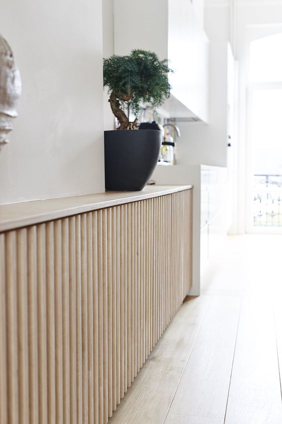 a chic light stained reeded screen is a perfect idea for a radiator cover as reeded and fluted designs are on top