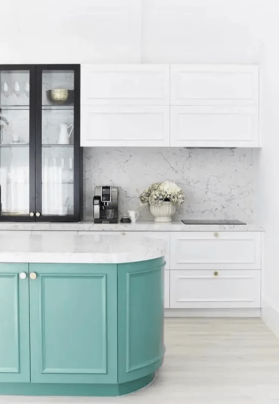 a chic white kitchen with shaker style cabinets and a black glass one for more drama, a turquoise curved kitchen island and white stone countertops