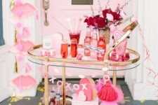 a colorful bar cart with burgundy and blush blooms, hot pink tassels and hearts all over