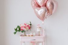 a cute blush bar cart with metallic pink heart balloons, a heart bunting and a floral centerpiece in pink and white