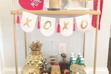 a glam Valentine bar cart with a XO bunting, a pink heart and a gold BAR marquee light