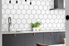 a graphite grey Scandinavian kitchen with an extended hexagon tile backsplash, pendant lamps and leather pulls