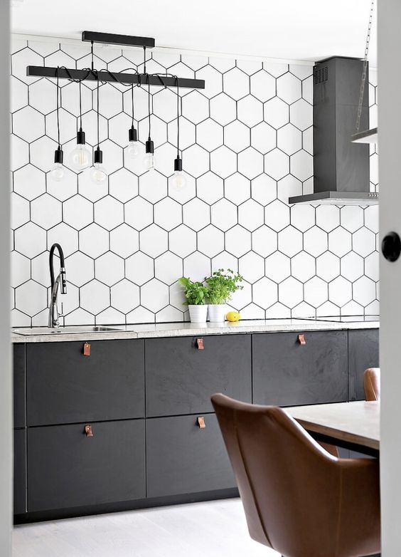 a graphite grey Scandinavian kitchen with an extended hexagon tile backsplash, pendant lamps and leather pulls
