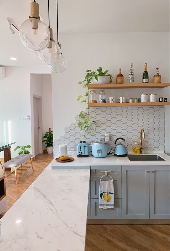a grey kitchen with only lower cabinets and an extended countertop, a hexagon tile backsplash and open shelves is wow