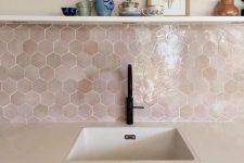 a matte dark green kitchen with a stone countertops, a pink hexagon tile backsplash and black fixtures