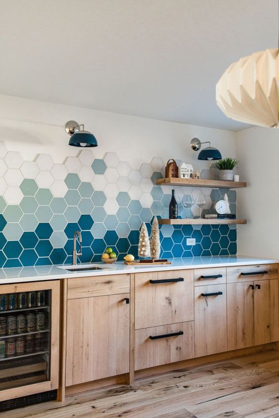 a modern stained kitchen with a bold ombre hexagon tile backsplash and open shelves plus black fixtures