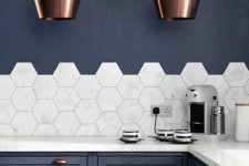 a navy kitchen with elegant copper touches and marble hexagon tiles on the backsplash that add a refined feel