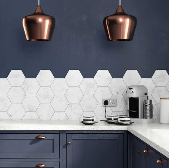 a navy kitchen with elegant copper touches and marble hexagon tiles on the backsplash that add a refined feel
