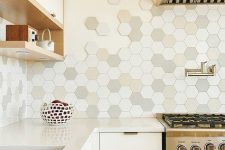 a neutral kitchen with a stained hood, neutral stone countertops, an eye-catching hexagon tile backsplash