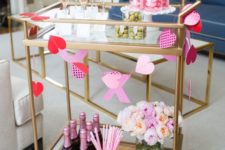 a romantic Valentine bar cart with a paper buntign in red and pink, with pastel blooms and everything pink