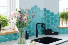 a sleek minimalist white kitchen with a bold turquoise hex tile backsplash and black fixtures is amazing