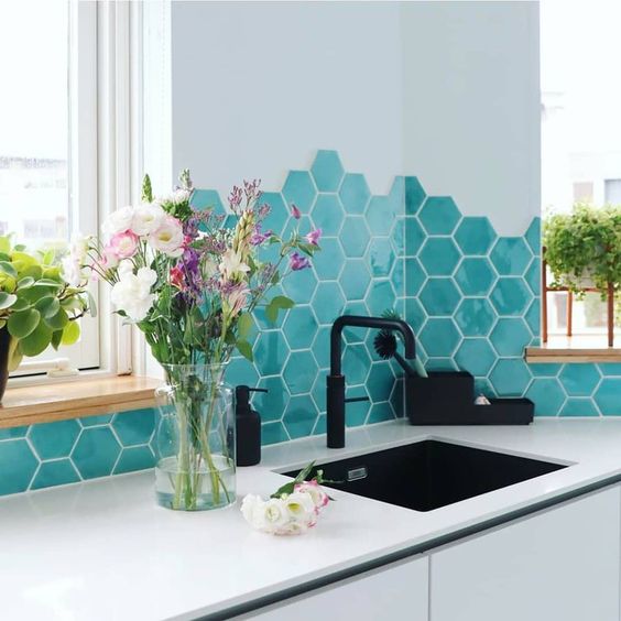 a sleek minimalist white kitchen with a bold turquoise hex tile backsplash and black fixtures is amazing