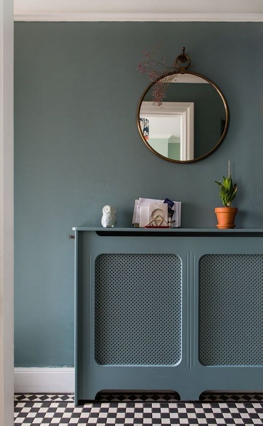 a teal wall and a matching radiator cover with cane screens to make it look lightweight and not stand out in the small space