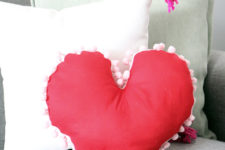 DIY red heart-shaped pillow with white pompoms