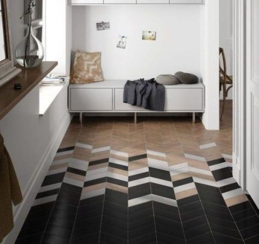 neutral tiles imitating wood go into black ones, all clad in a herrignbone pattern and with some touches of white for transitioning
