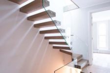 09 a floating staircase with steps attached to a glass banister looks very edgy and fresh