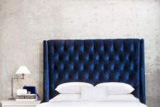 10 a navy upholstered bed with an oversized wingback headboard is a bold centerpiece for a bedroom