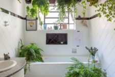 11 potted greenery hanging over the bathtub and some plants around the tub for a fresh feel