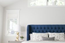 12 a bright blue bed with a tufted wingback headboard plus gold touches create an elegant space