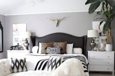 13 a black vintage bed with a wingback leather headboard and an arrangement of printed pillows