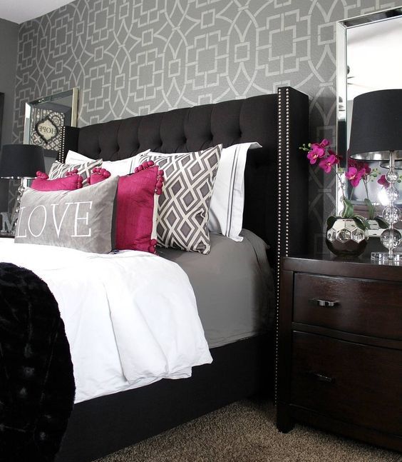 a bold bedroom with a black upholstered bed with a tufted wingback headboard with a nail trim