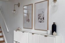 a beautiful white IKEA Stall hack made of several cabinets, with fluted panels and gold pulls is a stylish idea