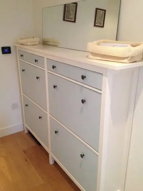 a cute IKEA Hemnes shoe storage in light blue with black knobs is ideal for a kids' space