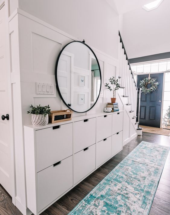 a large white console table attached to the wall made of IKEA Stall cabinets is a perfect idea for a modern farmhouse interior