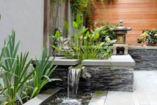 02 a modern and bold front yard waterfall clad with natural stone and tiles and with pebbles