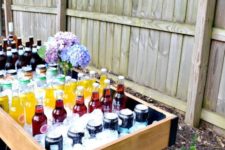 05 a large drink station of wood painted in a dramatic way and filled with ice cubes and a pastel flower centerpiece