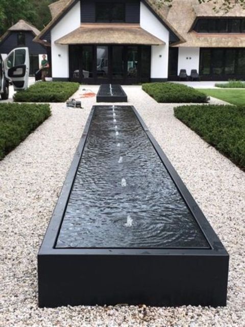 modern box fountains in the front yard boost the contemporary feel of the house and outdoor spaces