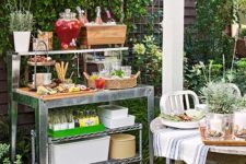 10 an outdoor metal station with a shelf, with potted greenery, drinks and appetizers for a party